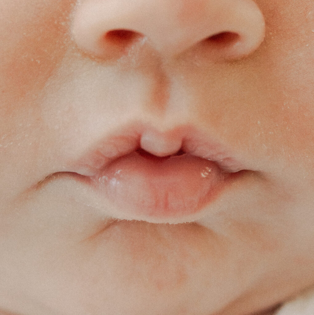 color photo of close up lips of newborn baby