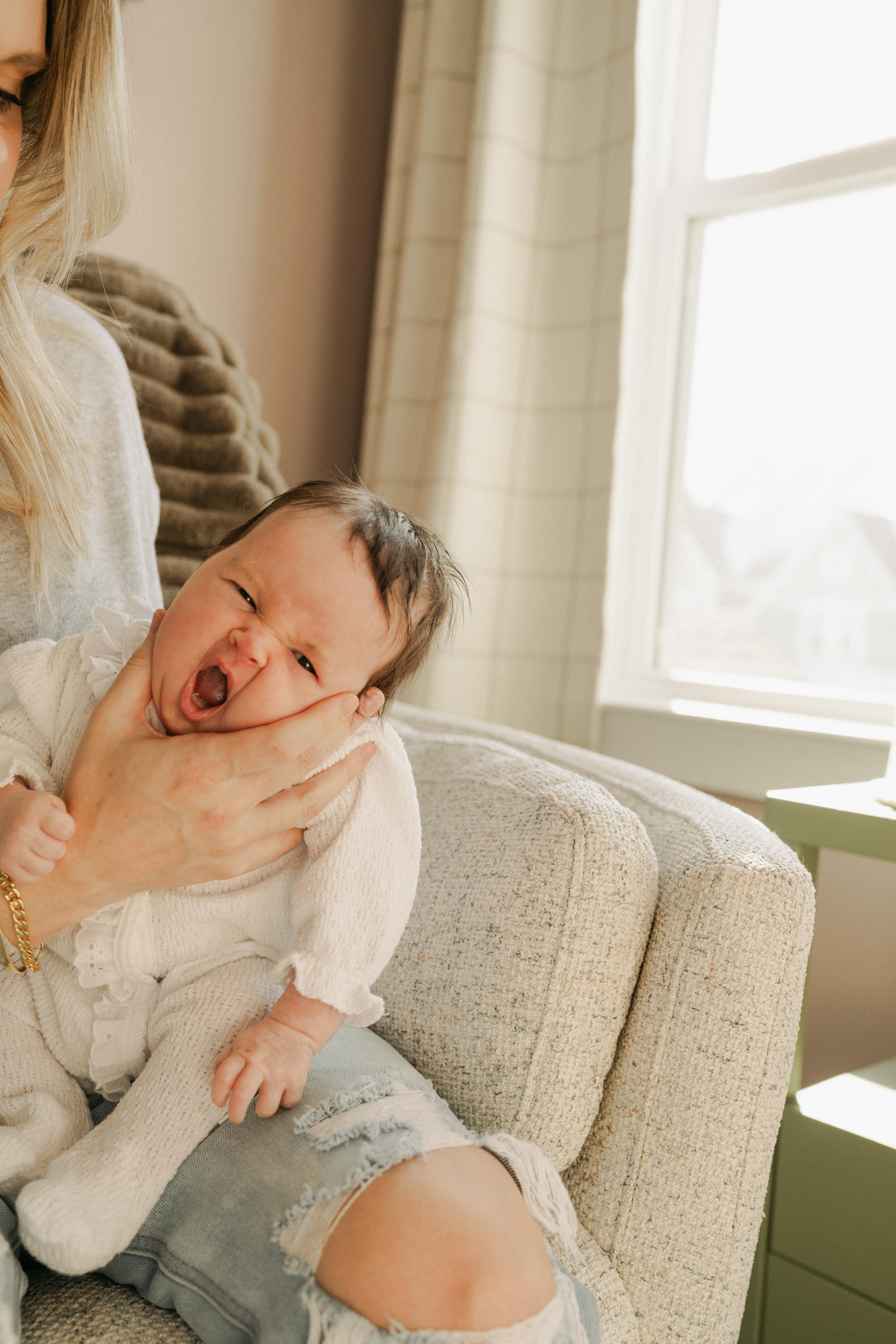 Baby being held to burp and baby is yawning